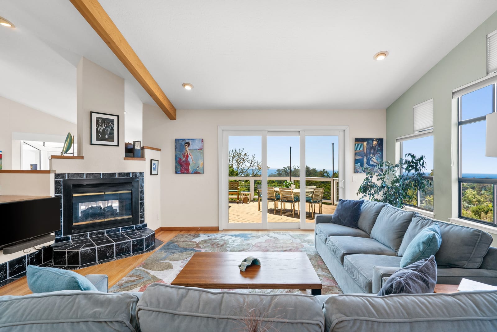 Living room with a fireplace and doors opening to the deck