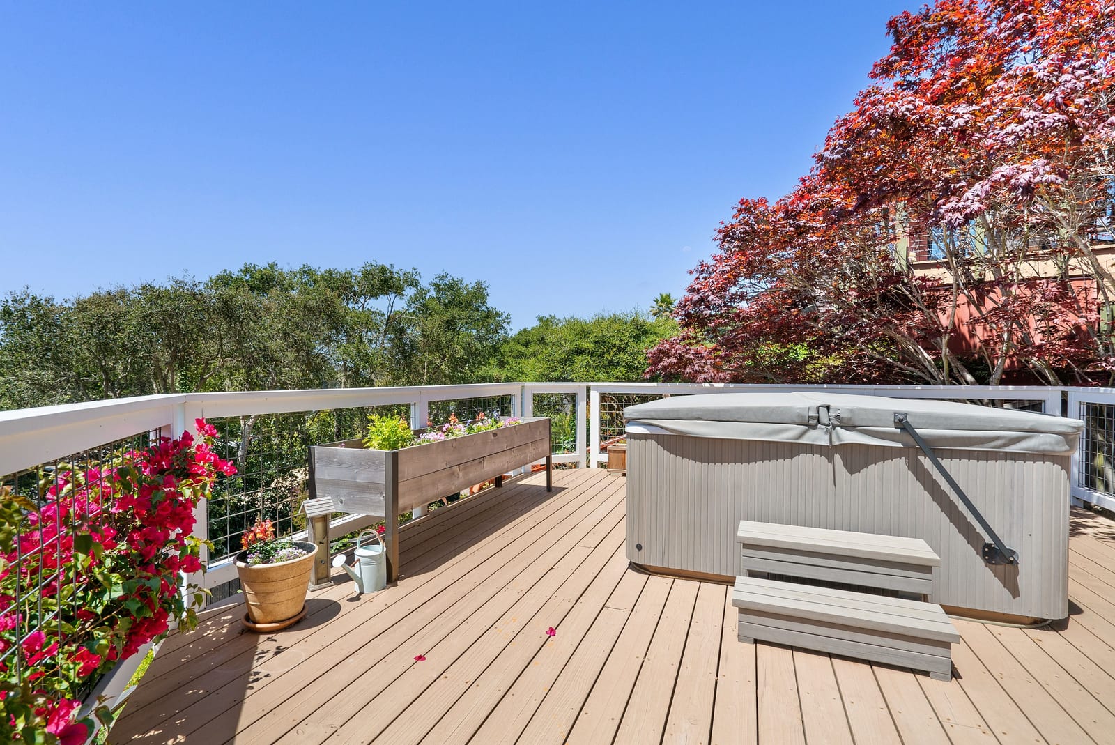 Hot tub on a sheltered deck beside garden planting